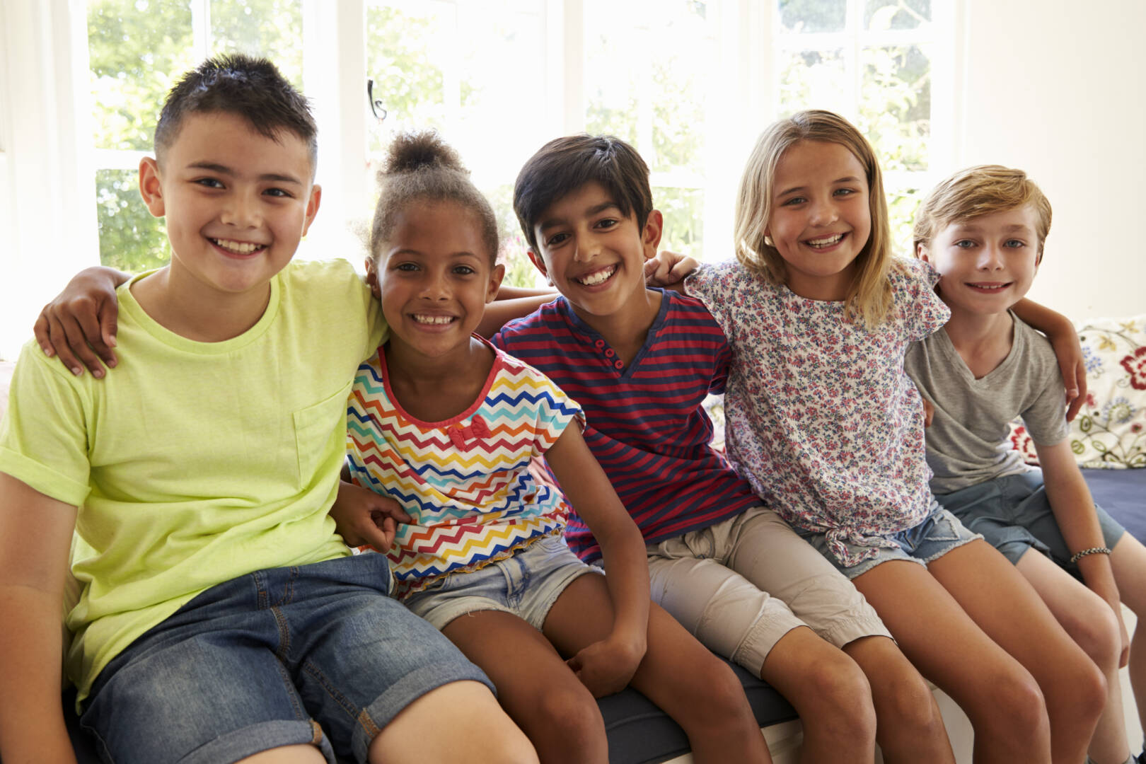 Group Of Multi-Cultural Children On Window Seat Together